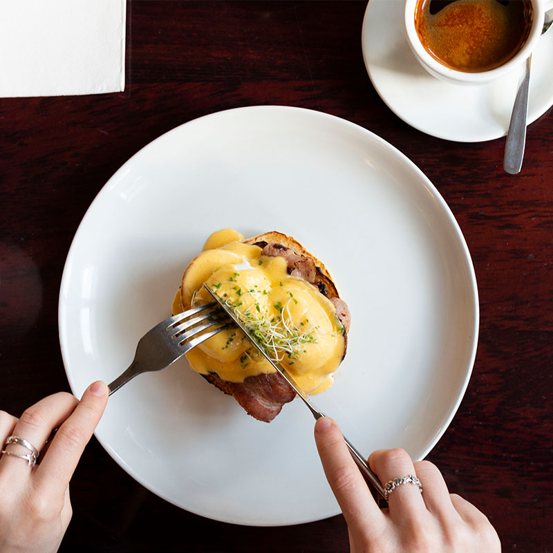 plate of eggs benedict with bacon